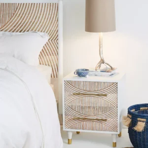 A wooden hand carved white nightstand.