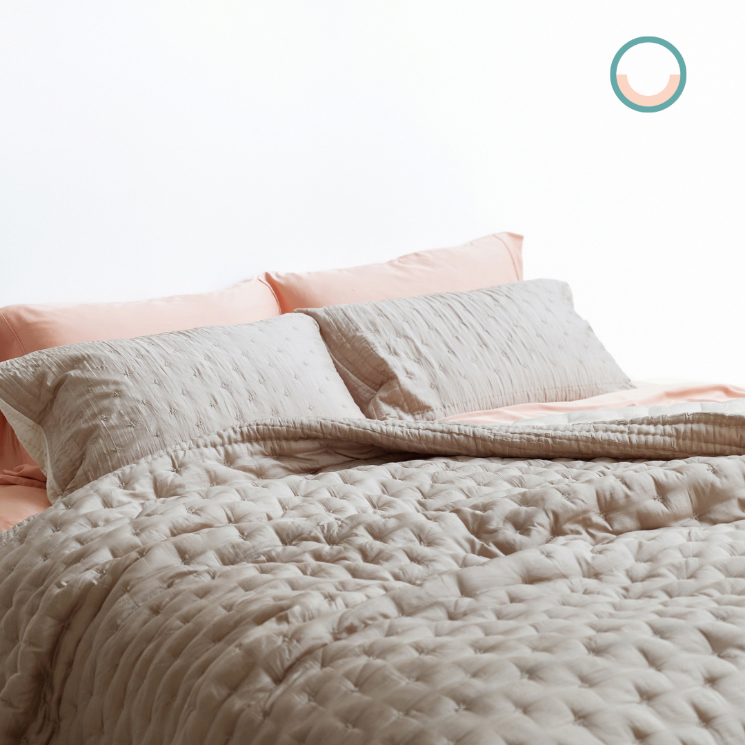 A bed with a beige duvet cover.