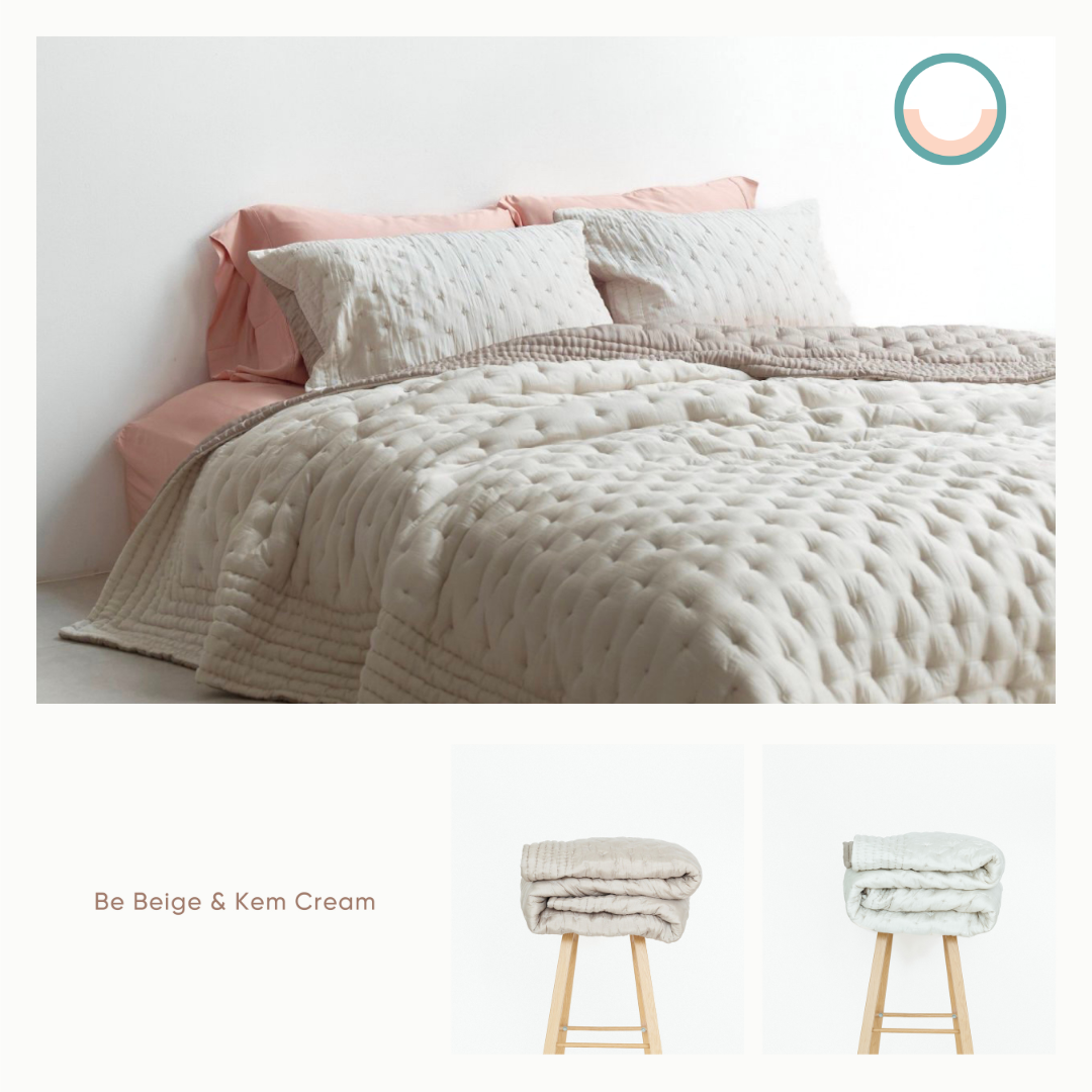 A bed with a white silk comforter and pink pillows.