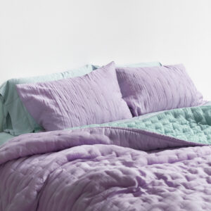 Purple silk bedding on a bed.