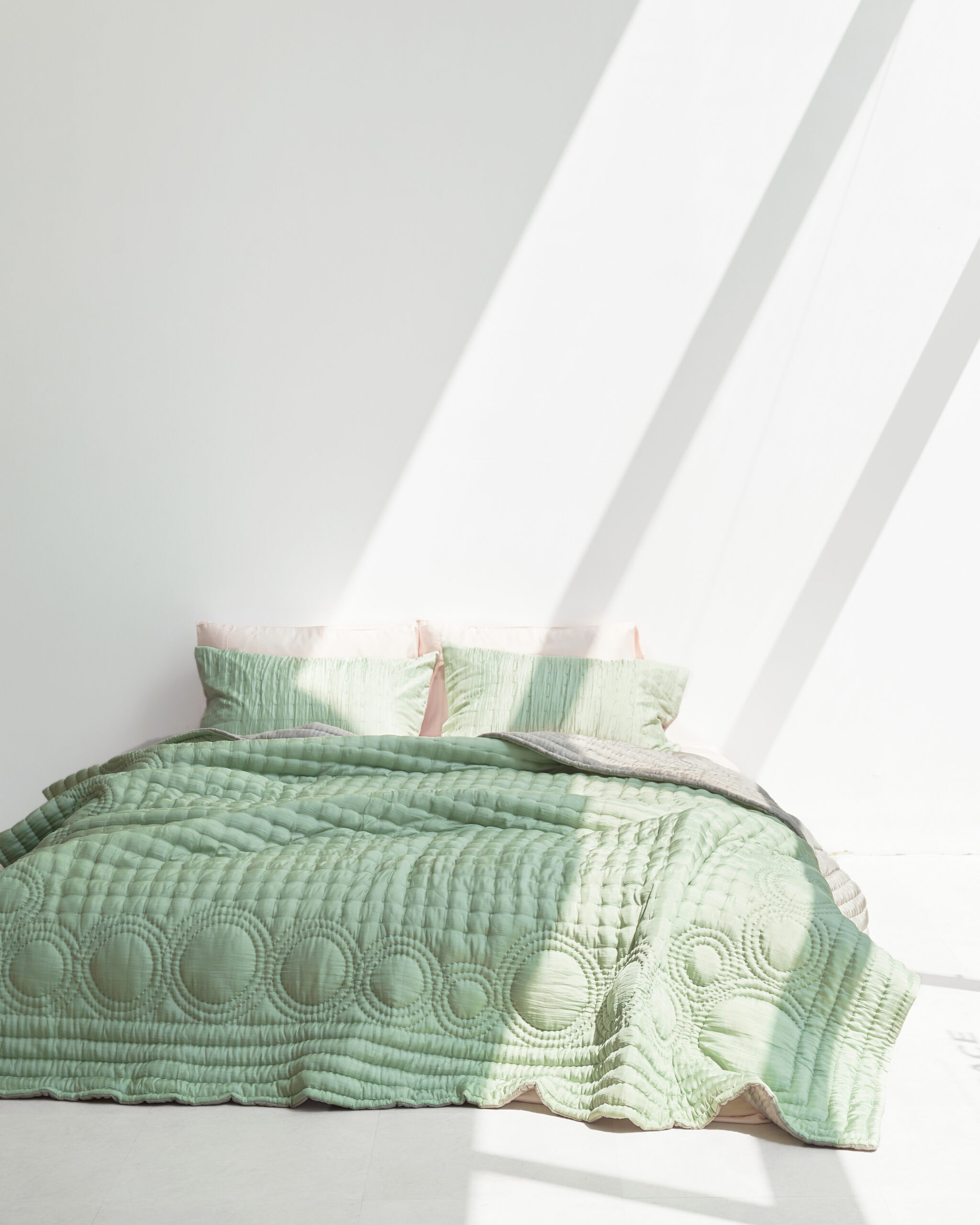 A bed with green bedding.