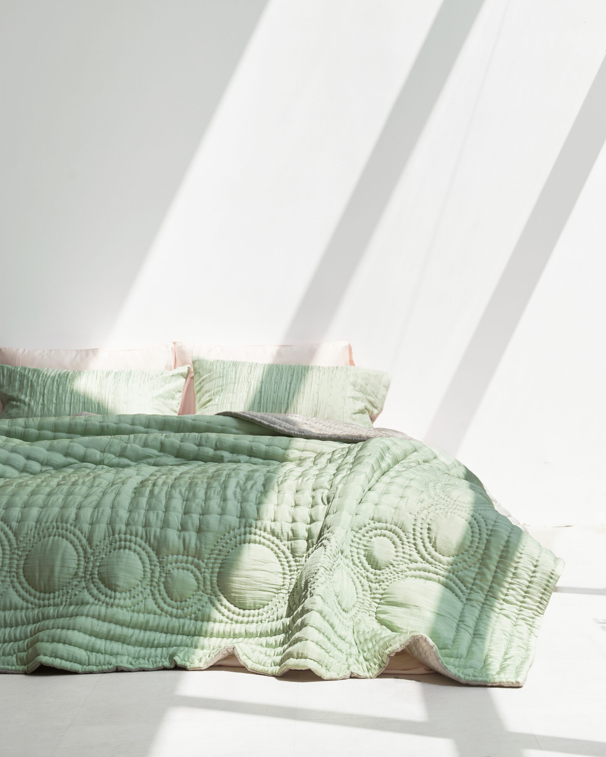 A bed with green bedding.