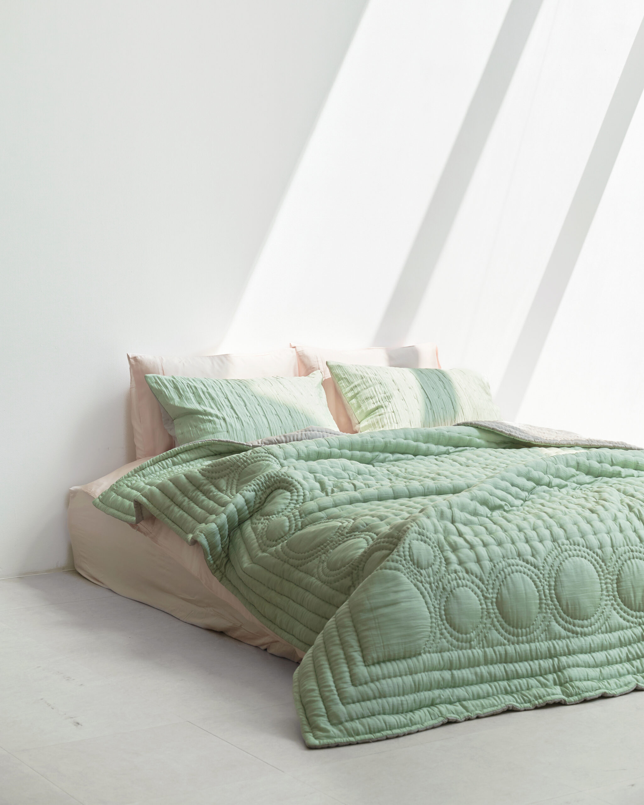 A bed with green bedding.