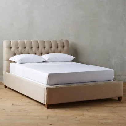 A bed with a tufted headboard and footboard.