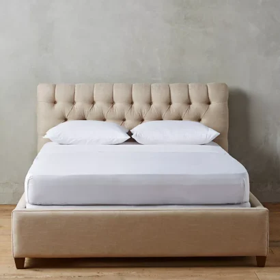 A bed with a tufted headboard and footboard.