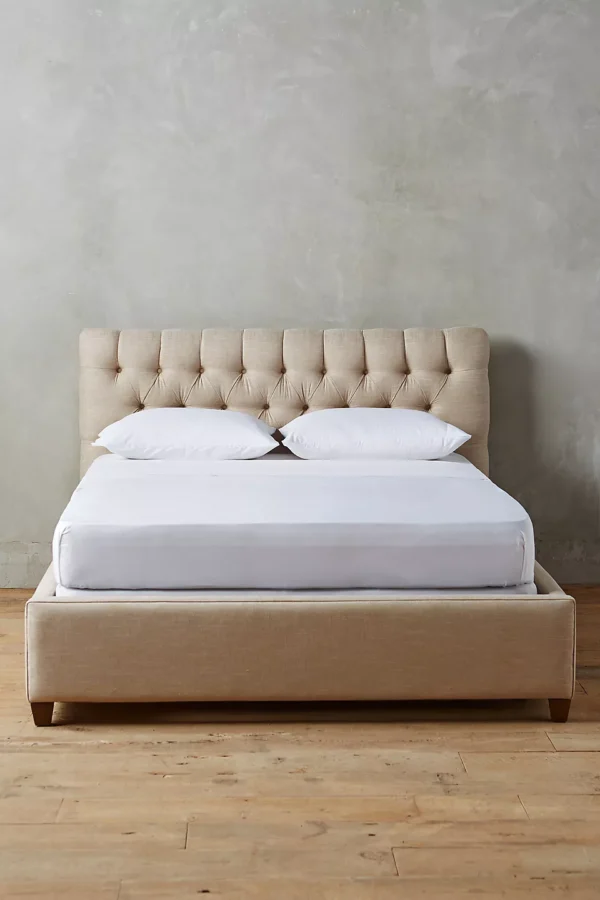 A bed with a tufted headboard and footboard.