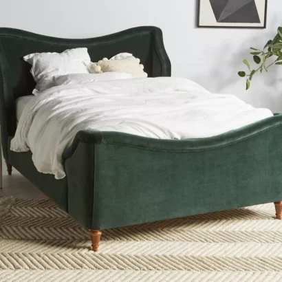 A green velvet bed in a bedroom with white bedding.