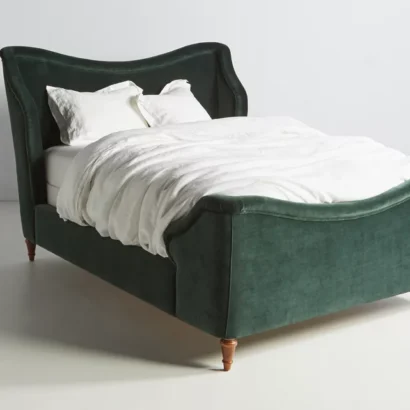 A green velvet bed in a bedroom with white bedding.