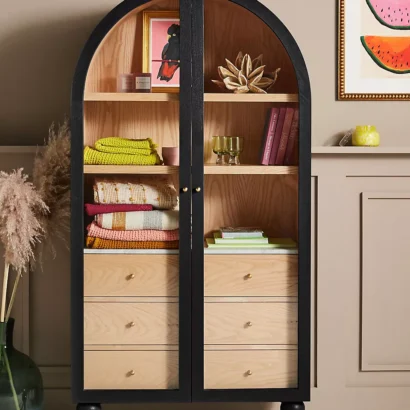 A wooden storage cabinet. An arched wood cabinet.