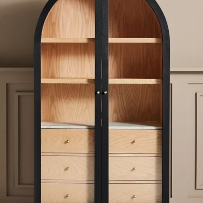 A wooden storage cabinet. An arched wood cabinet.